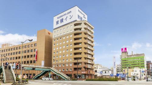 a tall building with a sign on top of it at Toyoko Inn Tokushima Ekimae in Tokushima