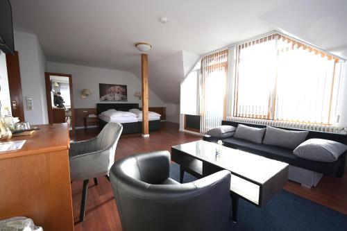 a living room with a couch and a table and chairs at Landhotel Hirsch in Sankt Johann