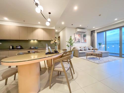 uma cozinha e sala de estar com mesa e cadeiras em The Sóng Apartments And Hotel 4 Stars em Vung Tau