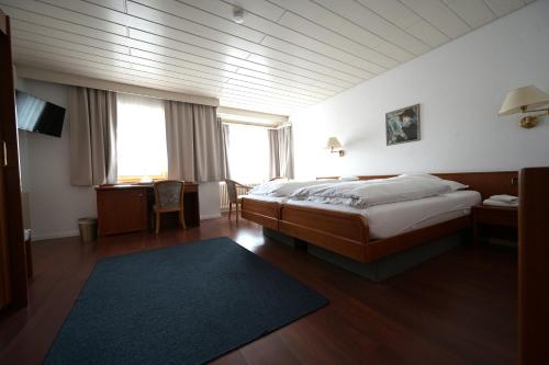 a bedroom with a bed and a large window at Landhotel Hirsch in Sankt Johann