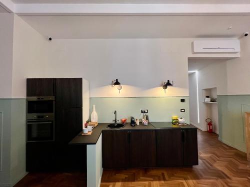 a kitchen with a black island in a room at Be Your Home - Guest House Fuori Dal Porto in Civitavecchia