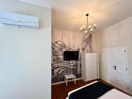 a room with a tv and a mural on the wall at Be Your Home - Guest House Fuori Dal Porto in Civitavecchia