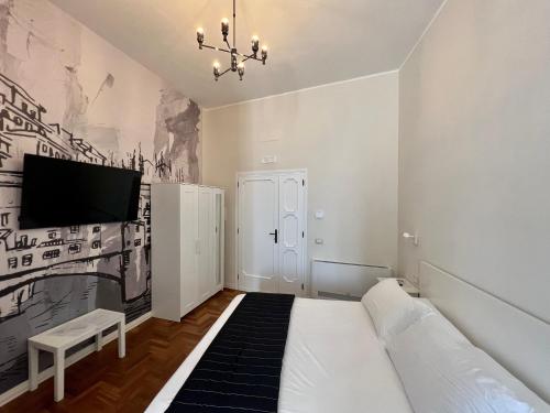 a bedroom with a bed and a tv on a wall at Be Your Home - Guest House Fuori Dal Porto in Civitavecchia