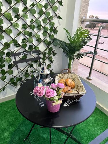 a black table with flowers and a basket of bread at Familyconfort oujda in Oujda