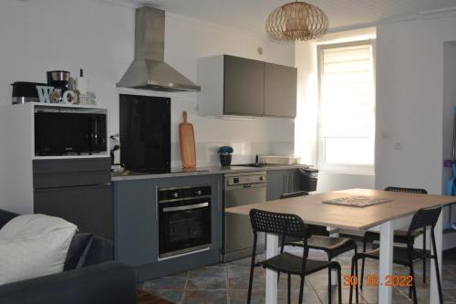 une cuisine avec une table et une salle à manger dans l'établissement Le Quatorze, à Bollène