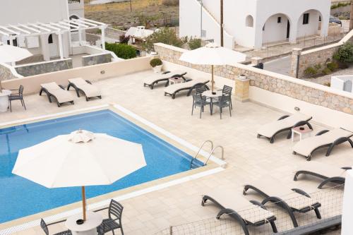 an outdoor patio with tables and chairs and a pool at Hotel Star Santorini in Megalokhori