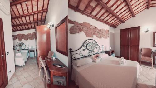 a bedroom with a bed and a desk with a desk at HOTEL Cala Buguto in Custonaci