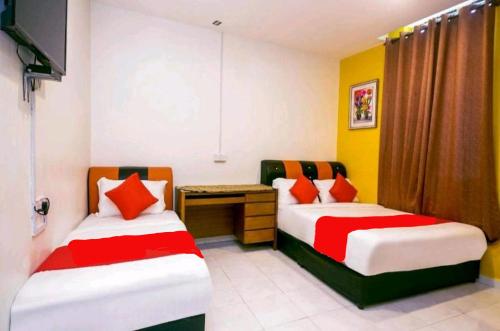 Habitación con 2 camas y escritorio. en Hotel Jerai Ct Inn, en Guar Chempedak