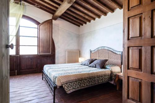 Un dormitorio con una cama y una puerta de madera. en La Casina- Podere della Collina, en Collelungo