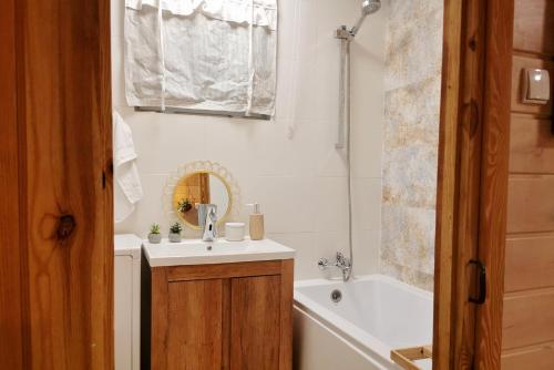 米沃姆溫的住宿－Domek na Skarpie，浴室配有盥洗盆和浴缸。