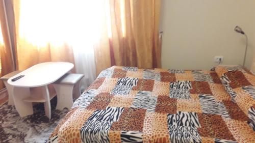 a bedroom with a bed and a desk and a table at Sadyba Margaryta in Truskavets