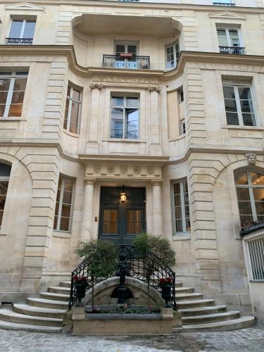 un bâtiment avec une fontaine devant lui dans l'établissement Superbe Duplex au Coeur de Montorgueil, à Paris