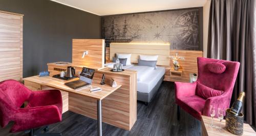 a hotel room with a bed and a desk and chairs at PLAZA Premium Columbus Bremen in Bremen