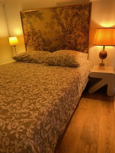 une chambre avec un lit avec un tableau sur le mur dans l'établissement Superbe Duplex au Coeur de Montorgueil, à Paris