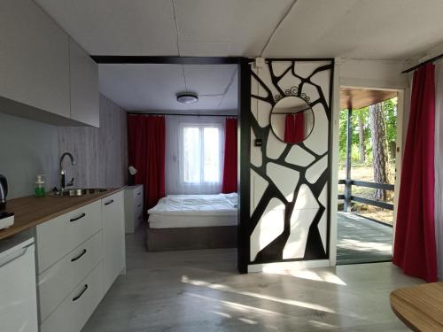 una cocina con una puerta que conduce a un dormitorio en Instytut Wypoczynku - domki nad jeziorem Mausz, en Sulęczyno