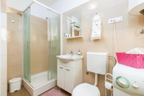 uma casa de banho com um chuveiro, um WC e um lavatório. em Relax Apartment Ive em Pula
