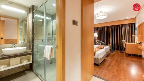 a bathroom with a sink and a shower and a bedroom at Express Inn The Business Luxury Hotel in Nashik