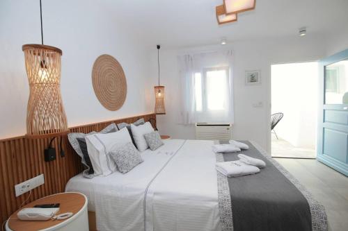 a bedroom with a large bed with white sheets and pillows at Harmony Boutique Hotel in Mýkonos City