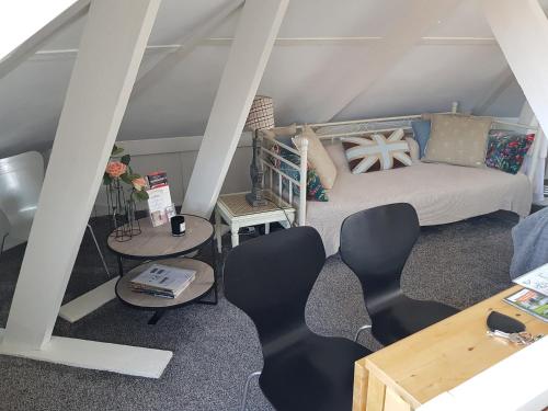 een woonkamer met een bank en tafels en stoelen bij Deluxe STUDIO-appartement Heemstede Zandvoort in Heemstede