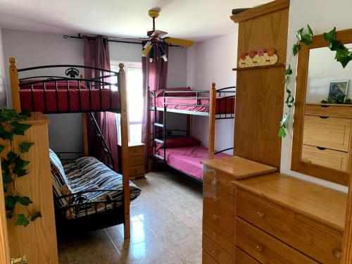 a bedroom with two bunk beds and a dresser at Apartamento dúplex Cabo de Gata in El Cabo de Gata