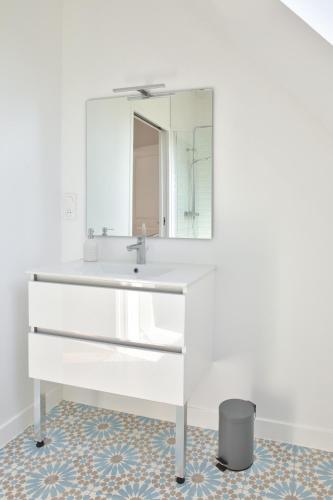 une salle de bain avec un lavabo blanc et un miroir dans l'établissement Vacances et détente en famille, à Plovan