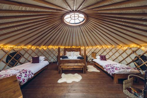 a yurt with two beds and a window at Scaldersitch Farm Boutique Camping Tipi with private wood fired hot tub in Sheen