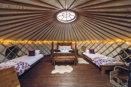 a yurt with two beds and a window at Scaldersitch Farm Boutique Glamping Tipi with private wood fired hot tub in Sheen