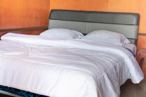 a large white bed with white sheets and pillows at Mentigen Homestay in Ngadisari