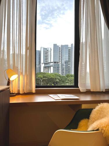 a desk with a window with a view of a city at ISA Hotel Amber Road in Singapore