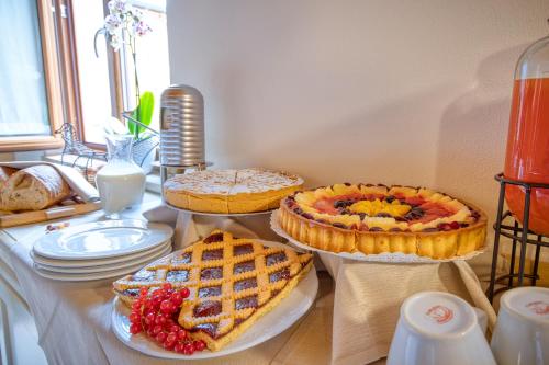 a table with three pies and plates on it at Appartamenti Villa Camporosso in Colà di Lazise