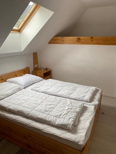 a bedroom with a large bed with white sheets at Waldschlössl Gasthof in Sankt Lorenzen ob Murau
