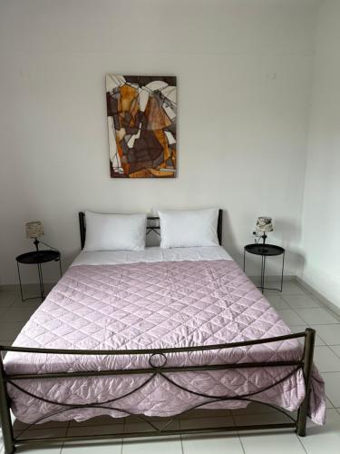 a bedroom with a bed with a purple comforter at Flampoura Apartments in Preveza