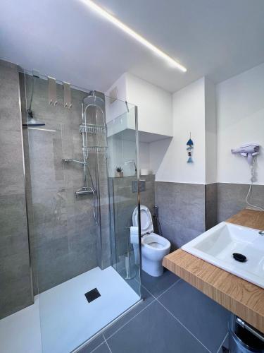 une salle de bain avec une douche, des toilettes et un lavabo dans l'établissement Gloria Maris Apartment, à Menton