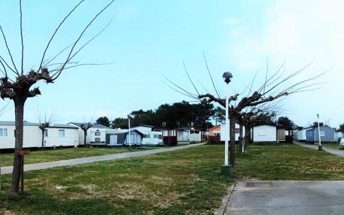 a street with houses and a street light and trees at Camping Mola! Surf Loredo in Loredo