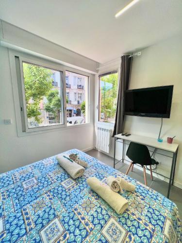 - une chambre avec un lit doté d'oreillers et une télévision dans l'établissement Gloria Maris Apartment, à Menton