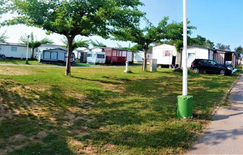 a group of mobile homes in a park with a pole at Camping Mola! Surf Loredo in Loredo