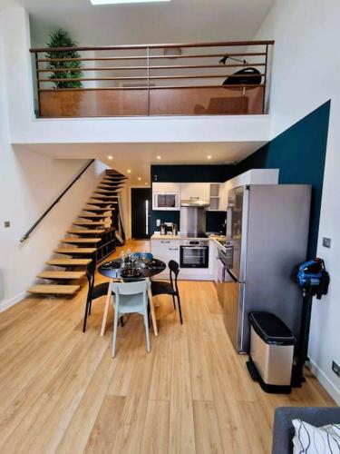 une cuisine et une salle à manger avec une table et un escalier dans l'établissement Le Bellay ¤ 2 Chambres ¤ Cour ¤10 mins Centre¤, à Amiens