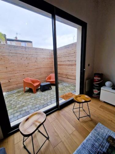 un salon avec deux chaises et une grande fenêtre dans l'établissement Le Bellay ¤ 2 Chambres ¤ Cour ¤10 mins Centre¤, à Amiens