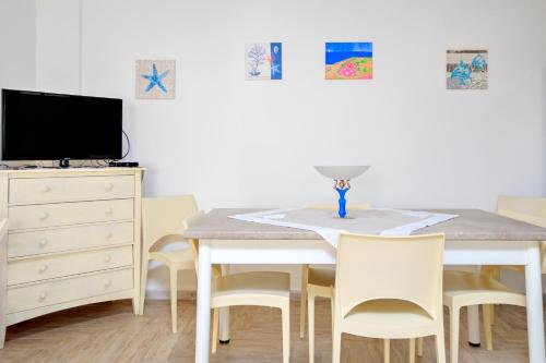 a dining room table with chairs and a tv at Appartamento Caterina in Siniscola