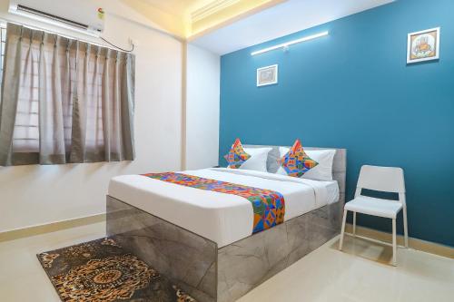 um quarto com uma cama king-size e uma cadeira em FabHotel Broholic Suites I em Hyderabad