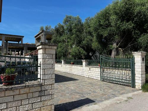 a stone fence with a gate and a stone wall at Dionysus Apartments & Studios in Syvota