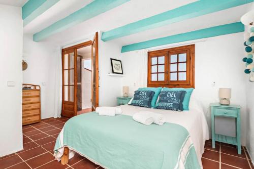 1 dormitorio con 1 cama con paredes azules y blancas en Sunset Tirant, en Fornells