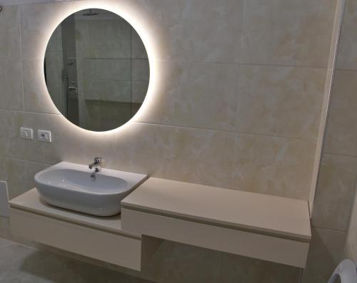 a bathroom with a sink and a mirror on the wall at NÓS apartment 1 in Shkodër