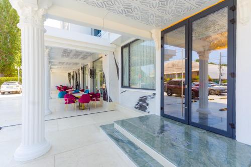 a white house with glass doors and tables and chairs at W Regal Boutique Hotel&Spa in Mamaia