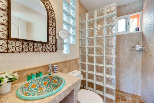 a bathroom with a sink and a toilet and a mirror at Villa Tiphareth in Marbella