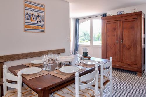 une salle à manger avec une table en bois et des chaises blanches dans l'établissement Belle maison pour 5 en pays Bigouden, à Plovan