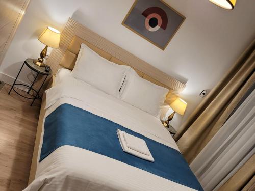 - une chambre dotée d'un grand lit avec des draps bleus et blancs dans l'établissement Adams Apartment Onix Blue, à Mamaia Nord – Năvodari
