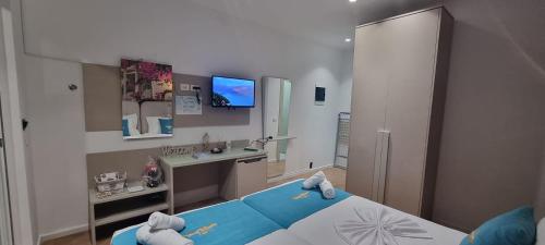 a bedroom with a blue bed and a desk at Suncoast Rooms Saranda near Port & Beach in Sarandë