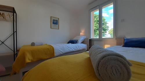 1 dormitorio con 2 camas y ventana en La Bucolique en Simandre