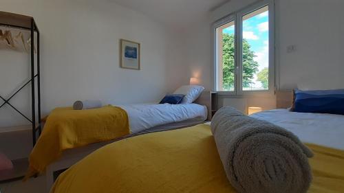 a bedroom with two beds and a window at La Bucolique in Simandre